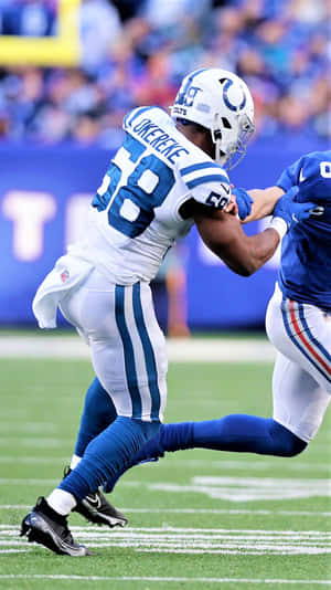 足球員在日間比賽中於草地上攔截對手。 — NFL 美式足球 壁紙