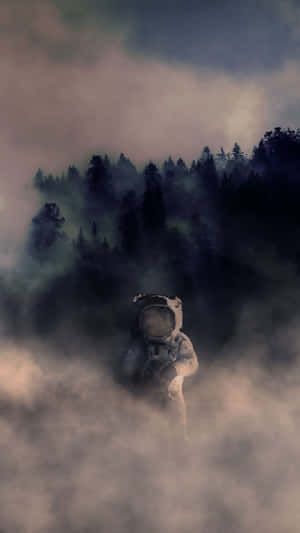 身穿白色太空衣的太空人站在迷霧中，背後有森林山丘 — 暮光 壁紙
