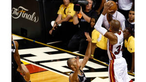 籃球運動員在NBA總決賽比賽中越過防守球員投籃。 — 喬許·艾倫 壁紙