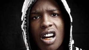 戴著帽子的年輕男子特寫，露出金牙，表情強烈。 — ASAP Rocky 壁紙