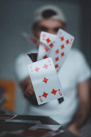 一名在撲克牌魔術中將撲克牌拋向空中的人。 — 魔法動圖 壁紙