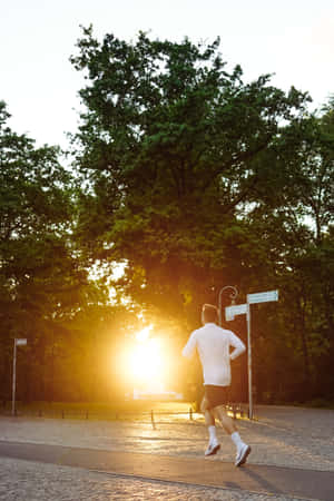 黃金時段在公園的鋪砌小徑上跑步的人。 — 運動 壁紙