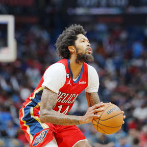籃球運動員在比賽中身穿紅色Pelicans球衣運球。 — 運動 壁紙