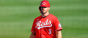 身穿紅色Reds球衣的棒球選手站在綠色球場上。 — 運動 壁紙