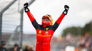 F1車手在賽道上高舉雙臂慶祝勝利。 — 勝利 壁紙