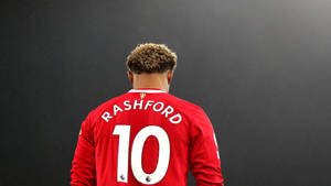 一名身穿印有Rashford名字和號碼10的紅色球衣的足球員的背面視圖。 — 運動 壁紙