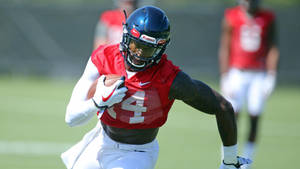 美式足球員在草地上持球奔跑 — Dk Metcalf 壁紙