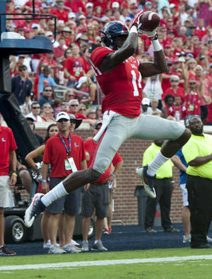 足球員在日間比賽中接住傳球，球迷歡呼。 — Dk Metcalf 壁紙