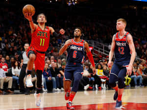 籃球運動員在比賽中越過兩名防守者投籃。 — 酷籃球 壁紙