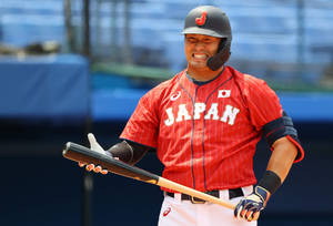 日本棒球選手身穿紅色球衣，緊握球棒，表情猙獰。 — 運動 壁紙