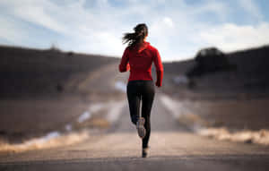 一名女子在乾燥的風景中的泥路上奔跑。 — Running 壁紙
