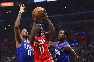 三名籃球運動員在NBA比賽中行動，一人投籃，兩人防守。 — 紐奧良鵜鶘 壁紙