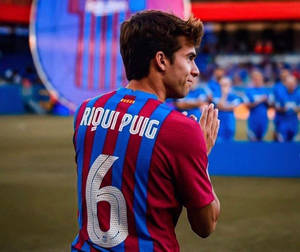 足球員Riqui Puig在球場上穿著6號球衣拍手。 — 運動 壁紙