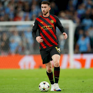 足球員在夜間球場燈光下於草地上盤球。 — 運動風 壁紙