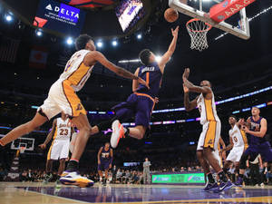 籃球運動員在比賽中跳起投籃，附近有防守球員。 — Devin Booker 壁紙