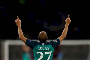 足球運動員Lucas 27號在夜間高舉雙臂慶祝勝利。 — 運動 壁紙