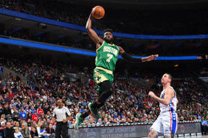 波士頓塞爾提克球員在NBA比賽期間於擠滿觀眾的場館中灌籃。 — 杰倫·布朗 壁紙