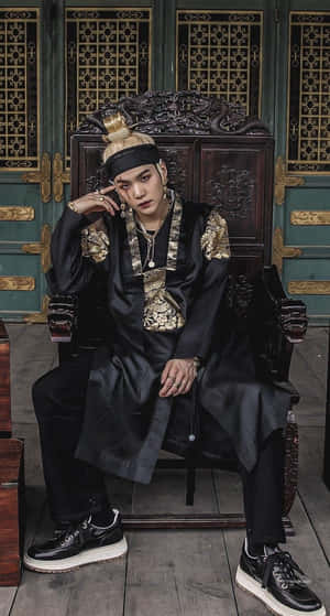 身穿傳統韓國皇室服飾的男子坐在華麗的木製王座上。 — 阿德里安·阿格雷斯特 壁紙