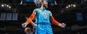 身穿藍色OKC球衣的籃球運動員在場館慶祝灌籃。 — 第七班 壁紙