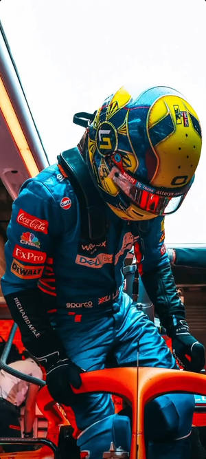身穿藍色賽車服和黃色頭盔的F1車手傾身進入橙色賽車。 — POCO C71 壁紙