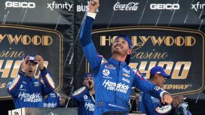 NASCAR車手與團隊成員在賽車頒獎台上慶祝勝利。 — 綠色天空 壁紙