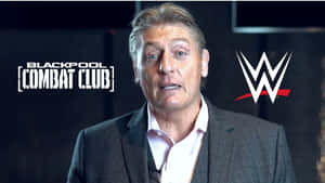男子身穿西裝在WWE Blackpool Combat Club活動中發言。 — 運動 壁紙