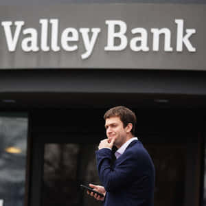 Valley Bank外穿西裝男子查看手機。 — 外灘群島 壁紙