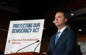 西裝男子在講台旁，標誌寫著「Protecting Our Democracy Act」。 — 高清 壁紙
