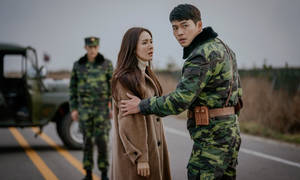 黃昏時分，一名士兵在軍車旁安慰一名女子。 — 愛的迫降 壁紙