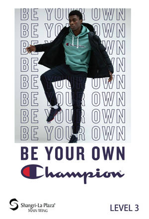 年輕男子穿著Champion服裝在品牌文字牆前擺姿勢。 — 冠軍 壁紙