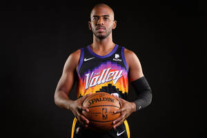 專業籃球運動員身穿太陽隊球衣，在黑色背景前手持 Spalding 籃球。 — 克里斯·馬汀 壁紙