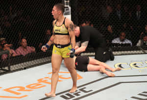 女性MMA拳手在UFC八角籠中比賽後勝利站立。 — 終極格鬥冠軍賽 壁紙
