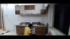 男子在夜間黑暗的房間裡安裝木製廚房櫥櫃。 — 男人 壁紙