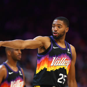 身穿「The Valley」球衣的籃球運動員在比賽中指向某處。 — 運動 壁紙