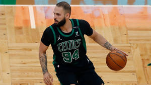 籃球運動員穿著塞爾提克隊服在比賽中運球。 — 波士頓塞爾提克 壁紙