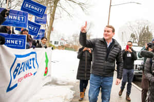 候選人Bennet在積雪的競選活動中向支持者揮手。 — 政治 壁紙