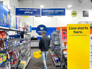男子在Best Buy商店通道中拿著黃色籃子前往收銀台。 — 最佳購買 壁紙
