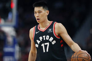 身穿暴龍球衣的籃球運動員比賽中運球。 — 克里夫蘭騎士隊 壁紙