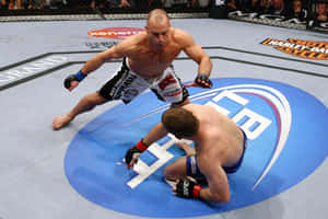 兩名MMA拳手在UFC八角籠內搏鬥，一人壓在另一人身上。 — 終極格鬥冠軍賽 壁紙