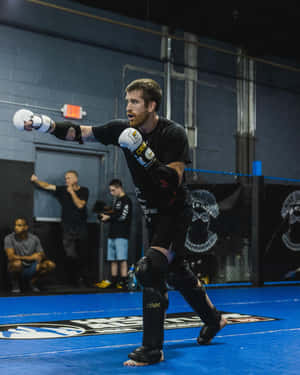 男性MMA拳手在訓練期間於藍色八角籠內出拳。 — 終極格鬥冠軍賽 壁紙