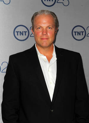 TNT 25週年活動中身穿黑色西裝和白色襯衫的男子。 — 亞當鮑德溫 壁紙