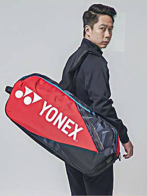 身穿黑色運動服的男子背著一個紅黑相間的Yonex羽毛球袋。 — 運動 壁紙