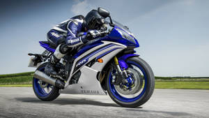 摩托車騎士在鋪砌道路上騎著藍色Yamaha R6傾斜入彎。 — 腳踏車 GIF 壁紙