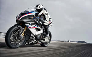 摩托車手在賽道上騎著白色、藍色和紅色的BMW HP4 Race比賽。 — 改裝摩托車 壁紙