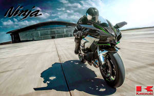 摩托車騎士在機場上騎著 Kawasaki Ninja 傾斜入彎。 — 機車 壁紙