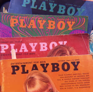一堆1960年代復古Playboy雜誌，封面色彩繽紛，有明顯磨損。 — 花花公子 GIF 壁紙