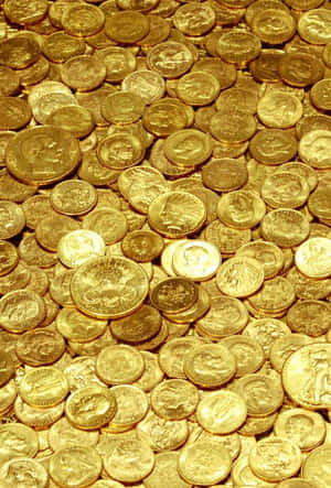 許多金幣堆疊在一起的特寫，帶有複雜設計。 — 金色動態 壁紙
