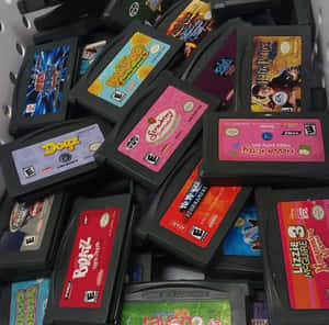 一堆帶有彩色標籤的 Game Boy Advance 遊戲卡帶。 — 2000年代 壁紙