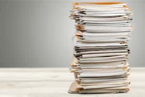 木桌上高聳雜亂的紙張和信封堆。 — Old Paper 壁紙