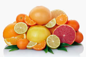 白色表面上色彩繽紛的新鮮柑橘類水果搭配綠葉。 — 柳橙 壁紙